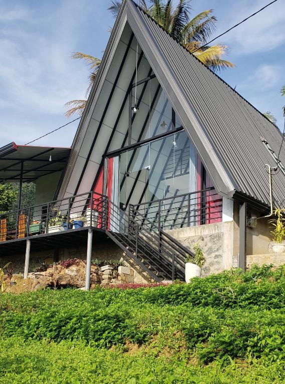 a house with a gambrel roof with a staircase at Ella Grand Cabin in Ella