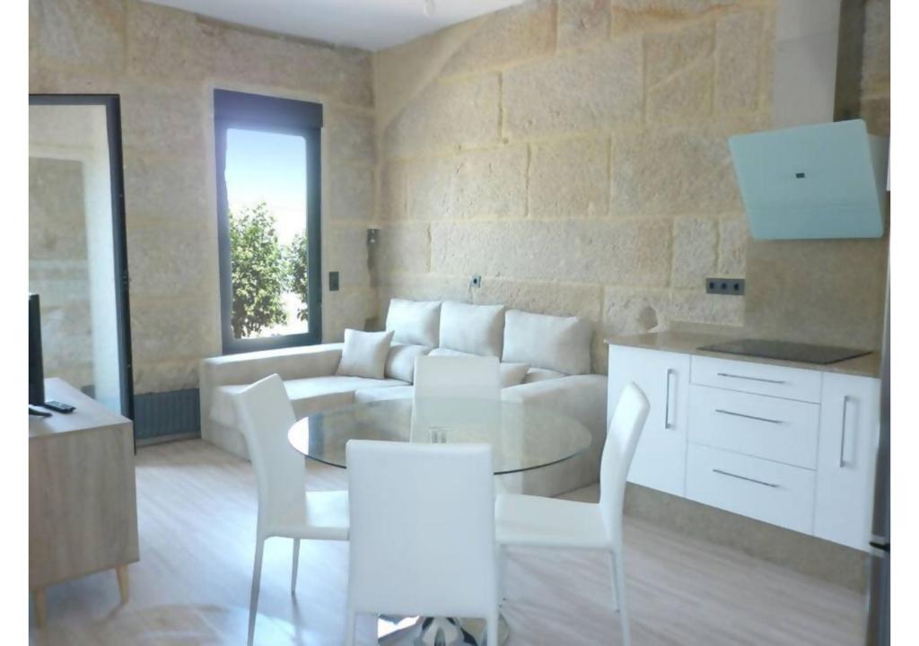 a living room with a couch and a table and chairs at Piso con vistas a 30m playa ALOJAMIENTOS VACAY in Bueu