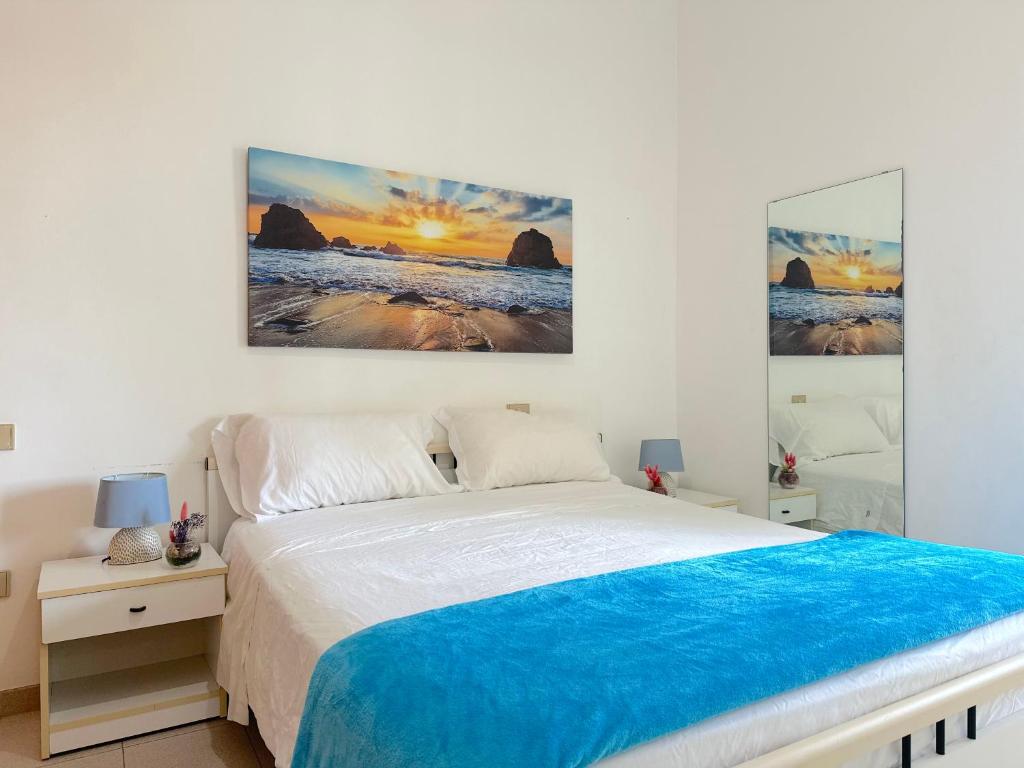 a bedroom with a bed and two paintings on the wall at Casa Mia - Baia Verde in Baia Verde