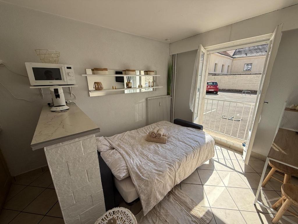 a small room with a bed and a microwave at Studio moderne au cœur de Compiègne in Compiègne