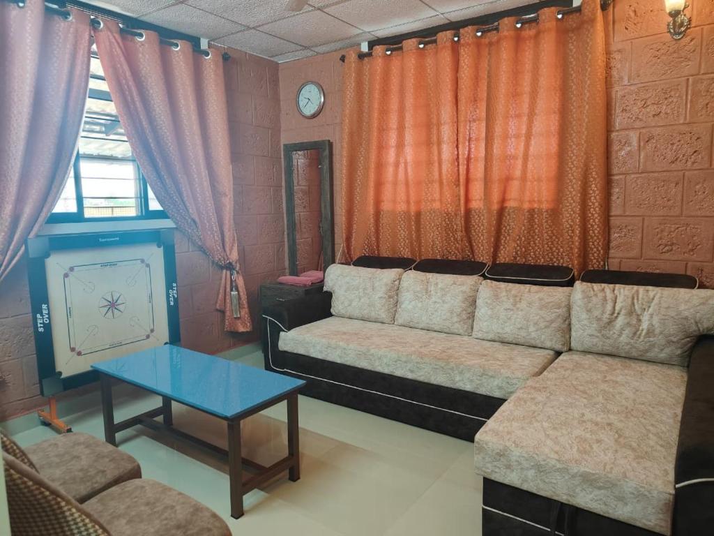a living room with a couch and a table at UDUPI HOMESTAY - Sunrise Home in Udupi