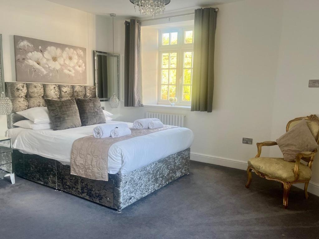 a bedroom with a large bed and a chair at The Mews & Studio in Ivybridge