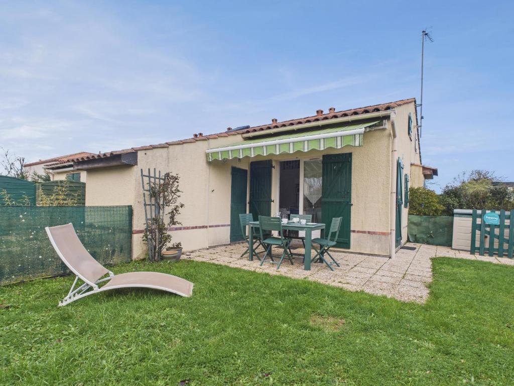 a house with a table and chairs in the yard at Maison proche Golf plage et piscine à Pornic in Pornic