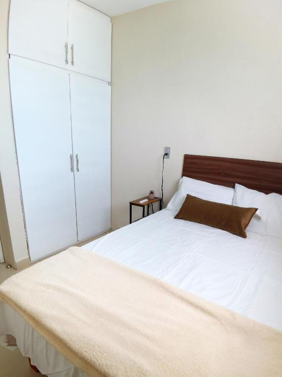 a bedroom with a large bed with white cabinets at Villa platino in Pachuca de Soto