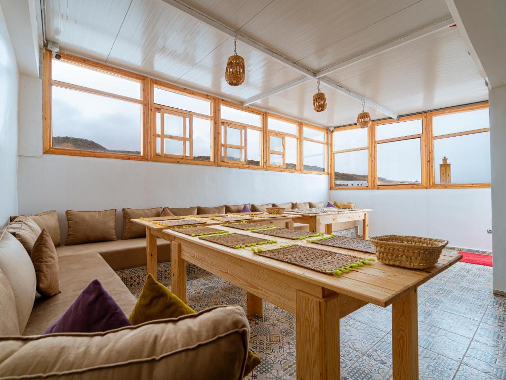 a living room with a table and a couch at Roots Surf House - Anza in Agadir