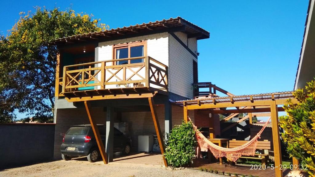 a small house with a porch and a balcony at Casa Kitnet Loft Bidu House in Imbituba