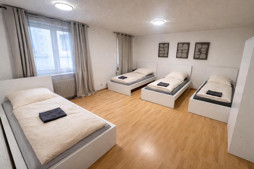three beds in a room with wooden floors at Apartment für Monteure & Gruppen in Koblenz-Ehrenbreitstein in Koblenz