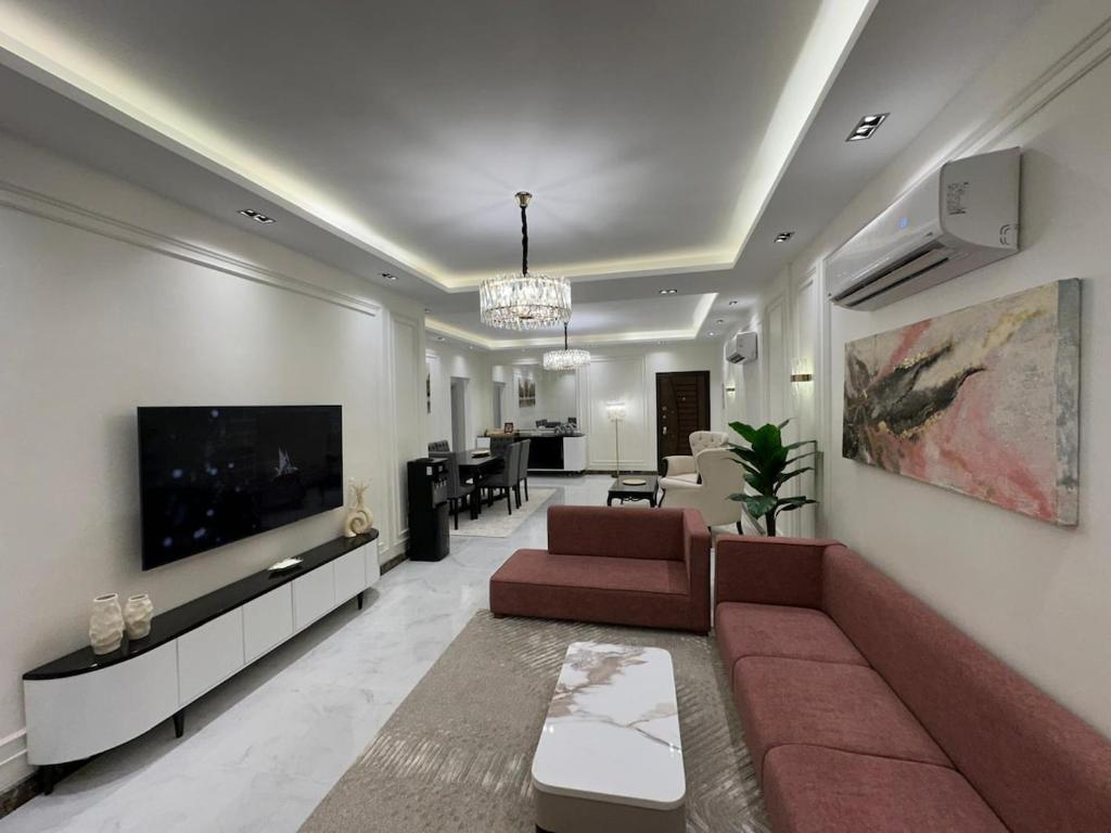 a living room with a couch and a flat screen tv at Super Luxury Private Complex Apt In New Cairo in New cairo