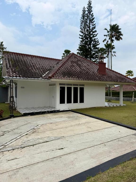 a white house with a red roof at Villa puncak 3 room in Cikundul