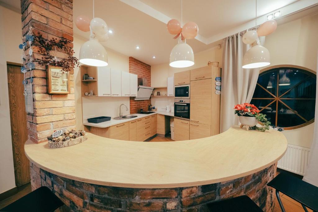 a kitchen with a large wooden counter in the middle at Beachside Guest House Piejuras nams in Ķesterciems