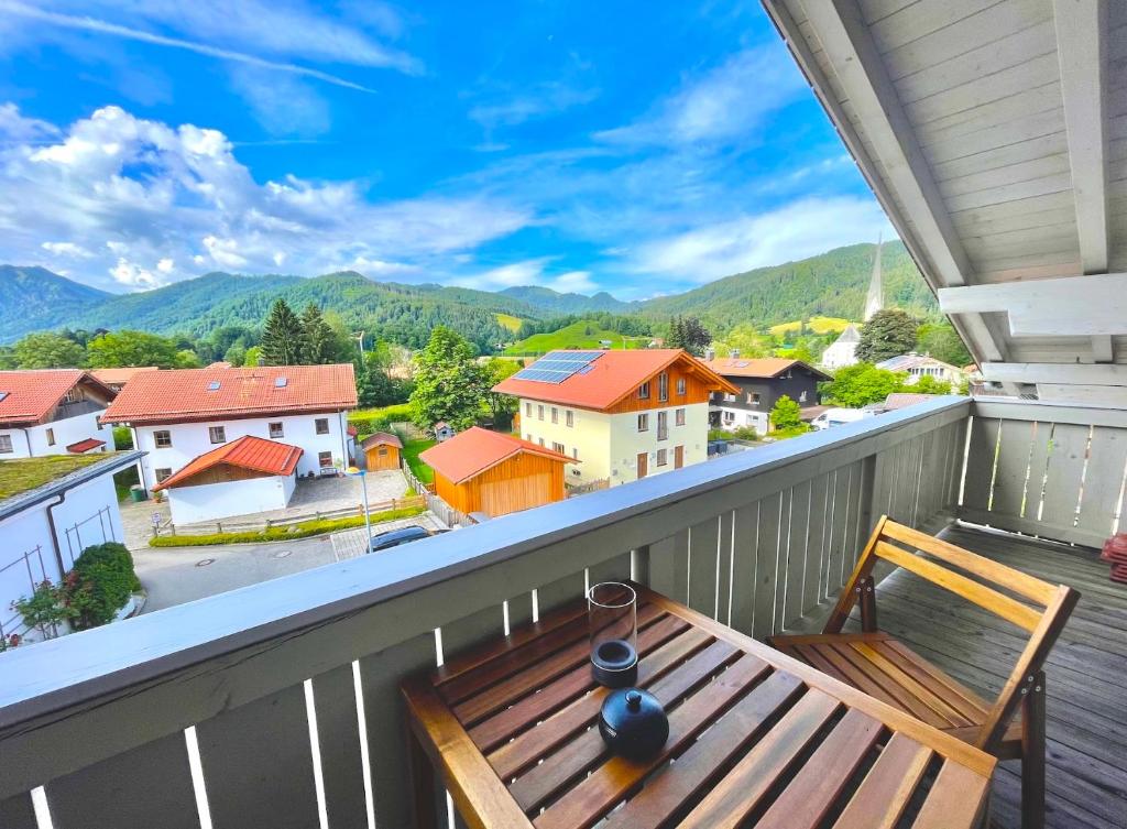 a wooden bench on a balcony with a view of mountains at Ferienwohnung "Krainsbergkogel" - Edles Dachgeschossapartment mit Bergblick in Schliersee