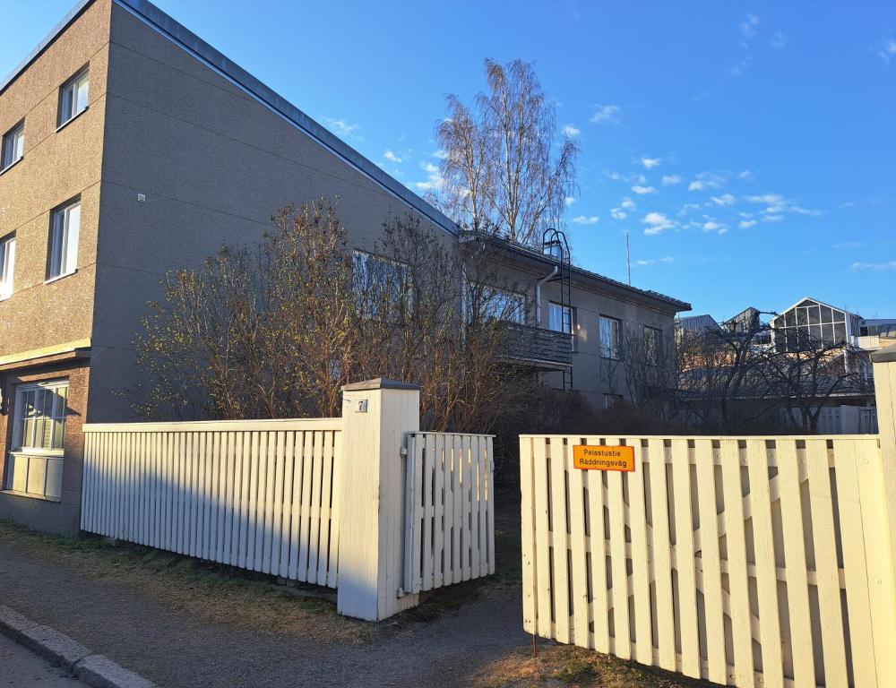 a white fence in front of a building at Huoneisto Kuusi in Kokkola