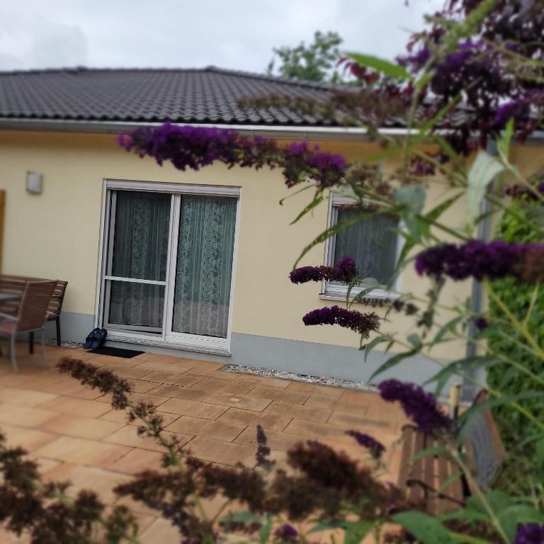 a patio with purple flowers in front of a house at Ferienwohnung Weber in Mühlau