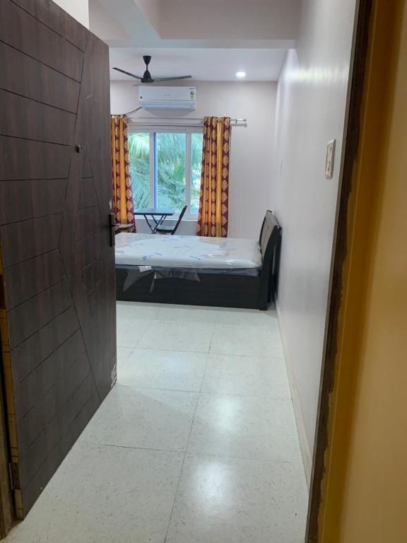 a hallway of a room with a bed and a window at Aasra Studios in Agonda