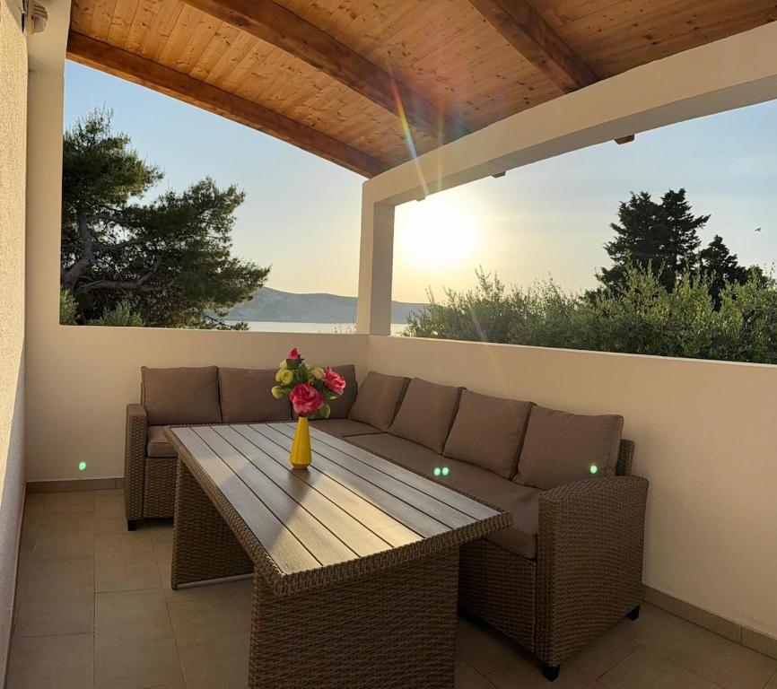 a patio with a wooden table and a couch at Coastal dream in Razvala