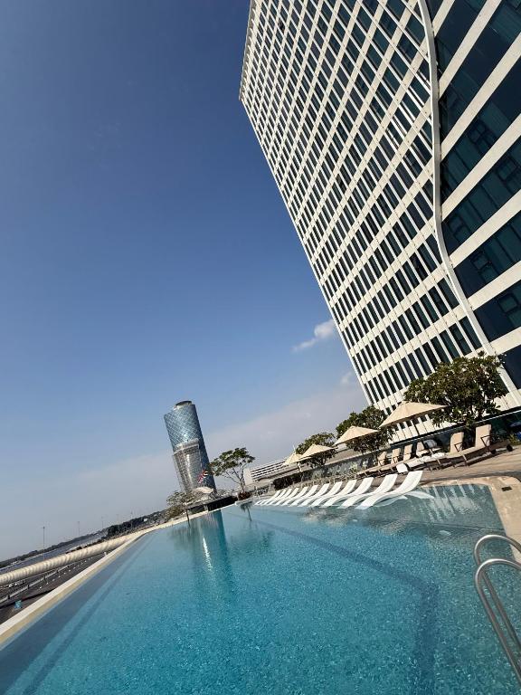 a swimming pool in front of a tall building at Capital Suites Hotel & Residences in Abu Dhabi