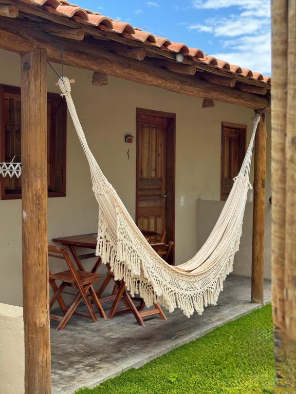 a hammock on the porch of a house at Vila Kairós in Caraíva