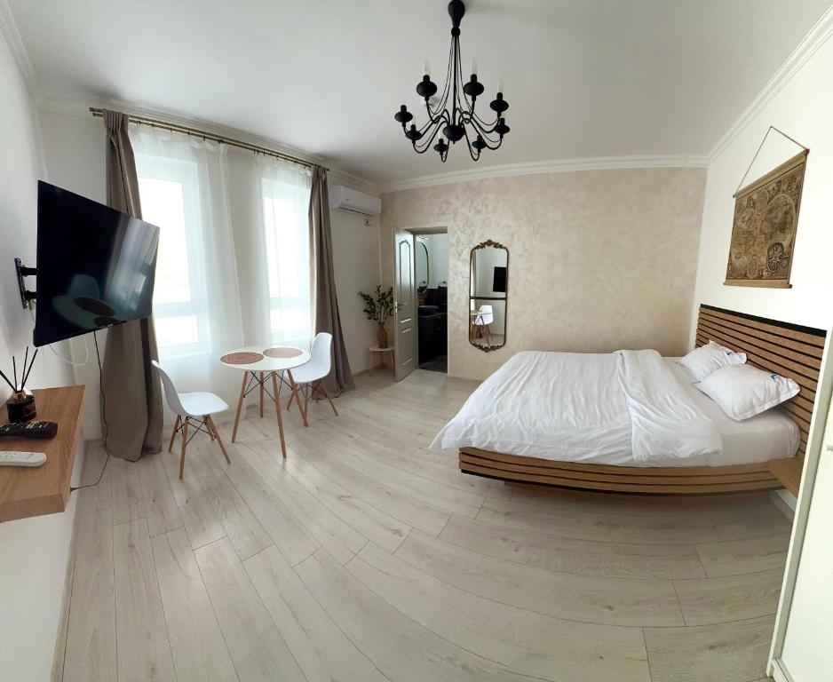 a bedroom with a bed and a table and a tv at Cleo Residence 5 Ghiroda in Ghiroda