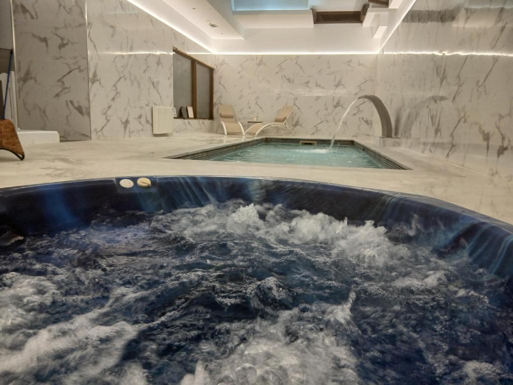 a large bath tub filled with water in a bathroom at LA CASONA Encanto Rural - ApartaHotel SPA Llanes in Llanes