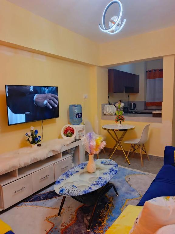 a living room with a tv and a table at Atis Smart Stay in Kisumu