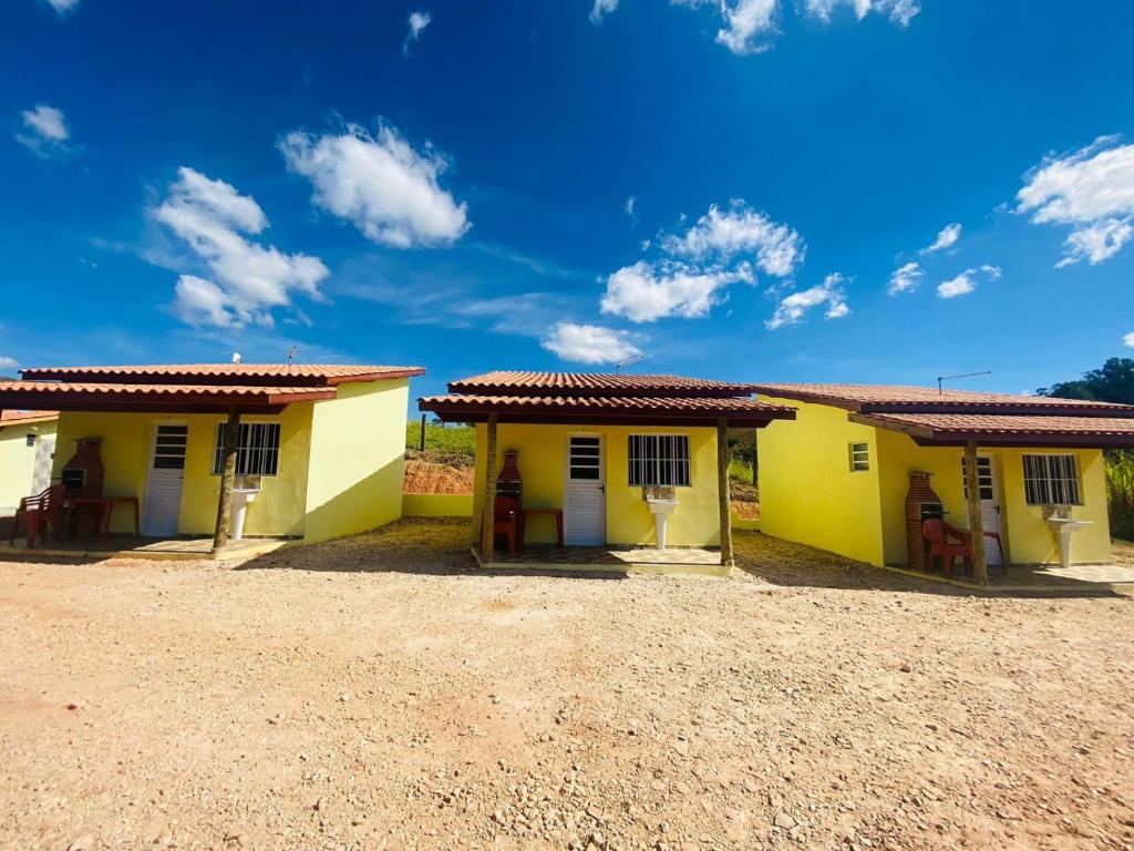 a pair of yellow houses with red roof at Pousada Helena e Heloá in Serra Negra