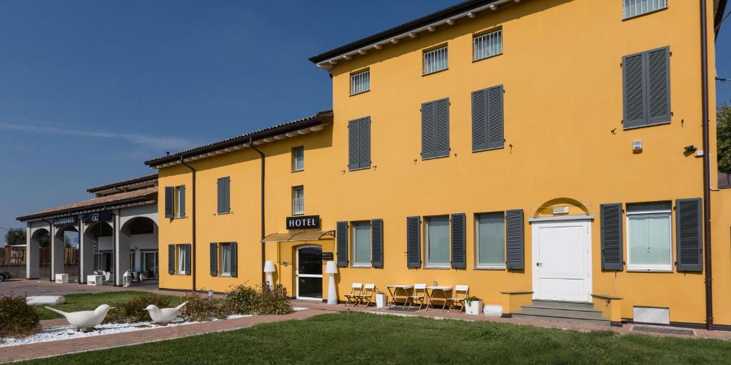 a yellow building with a white door at Hotel Forlanini 52 in Parma