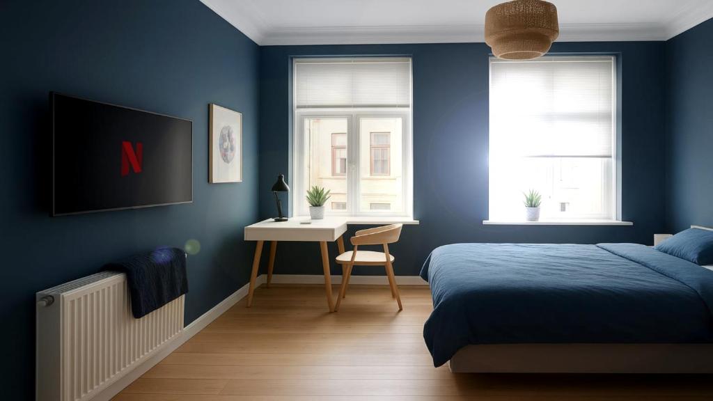 a blue bedroom with a bed and a desk at Greenbrook Blue Suite in Aalborg