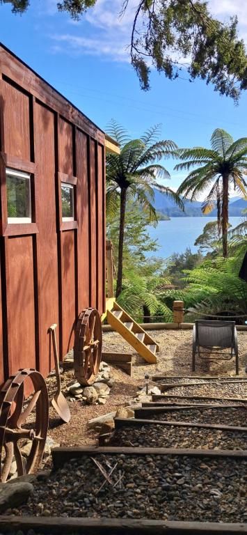 a train car sitting on tracks next to a building at The Clearing - Rustic Wagon by the Sea in Picton