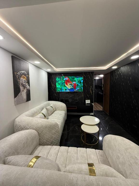 a living room with two couches and a flat screen tv at Casa ibague in Ibagué