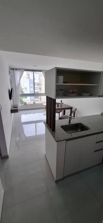 a kitchen with a sink and a table in it at ADS DEPARTAMENToS 2 in La Plata