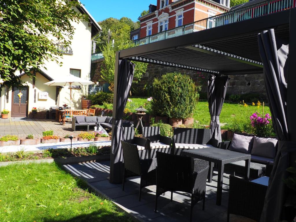 a pergola with tables and chairs in a yard at Piroska Pension in Olbernhau