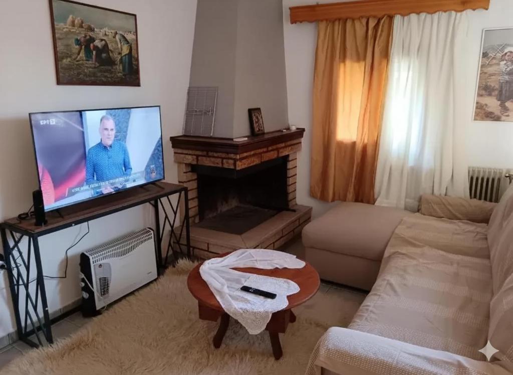 a living room with a flat screen tv and a couch at Super central apartment with a view in Karpenisi