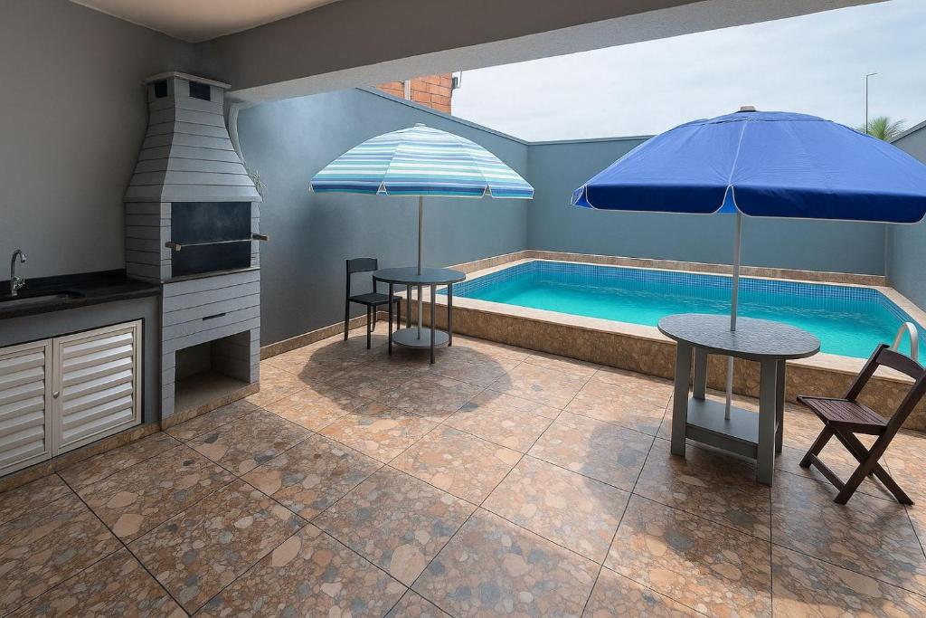 a kitchen with a pool and a table with an umbrella at Sobrado Maré Mansa in Peruíbe