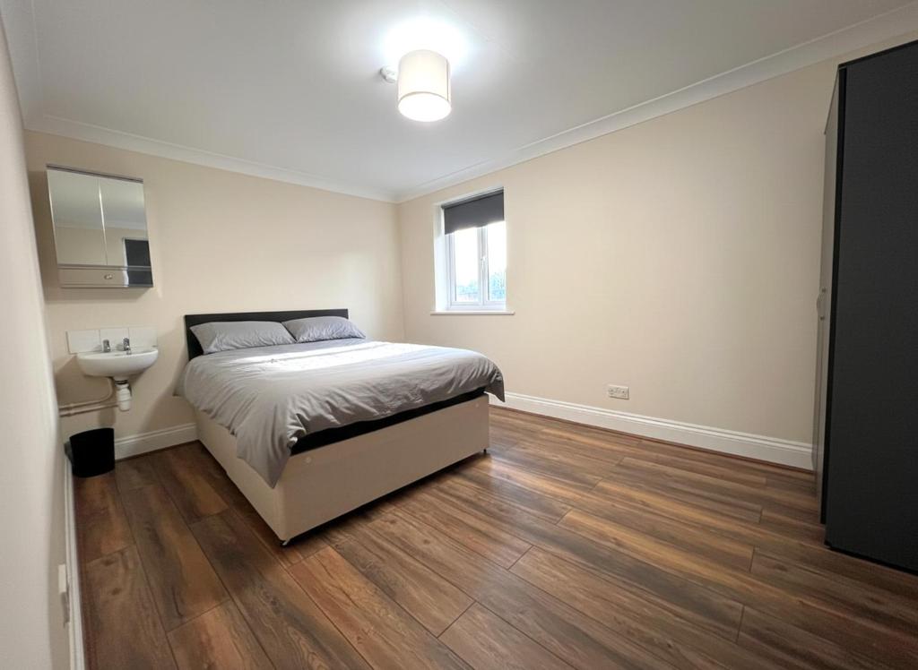 a bedroom with a bed and a wooden floor at Atherley House - Winter Sale! Spacious Self Catered Rooms in Southampton