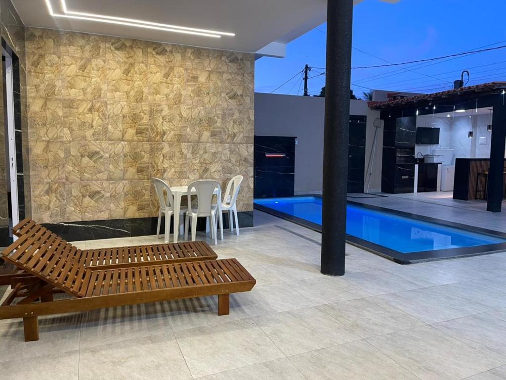 a patio with chairs and a swimming pool at Casa veraneio2 in Camacari