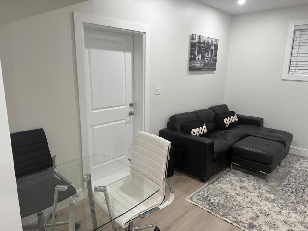 a living room with a black couch and a chair at 2 Bedrooms Private EntRance wifi Free Parking in Prince George