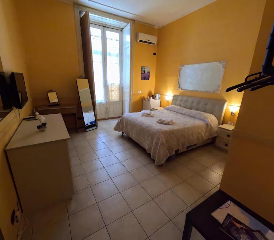 ein Schlafzimmer mit einem Bett und einem großen Fenster in der Unterkunft Hotel Gorizia in Catania