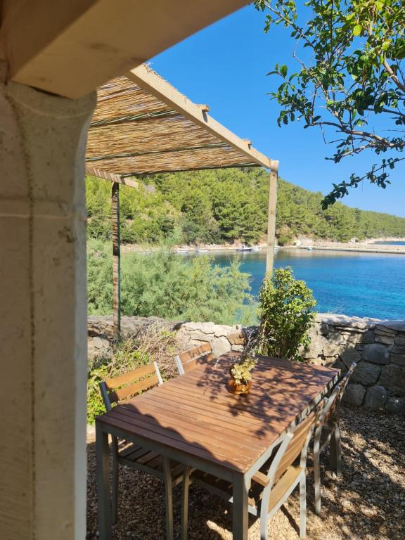 a wooden table and chairs with a view of the water at Apartment Stiniva in Hvar