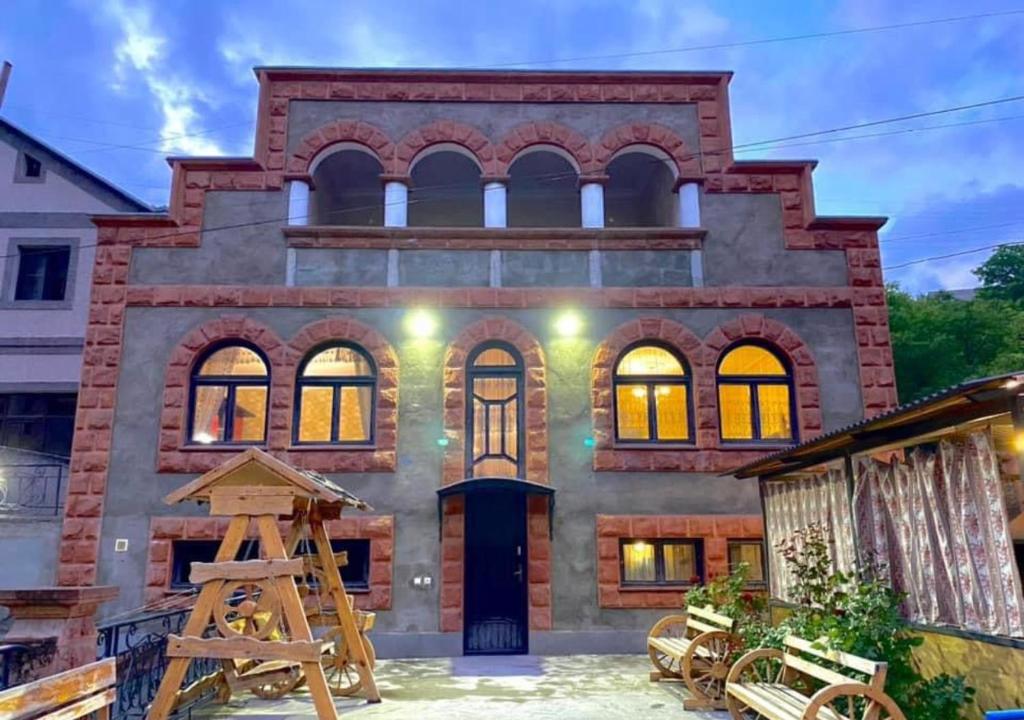 an old brick building with a wooden ladder in front at RedRose guest house Dilijan in Dilijan