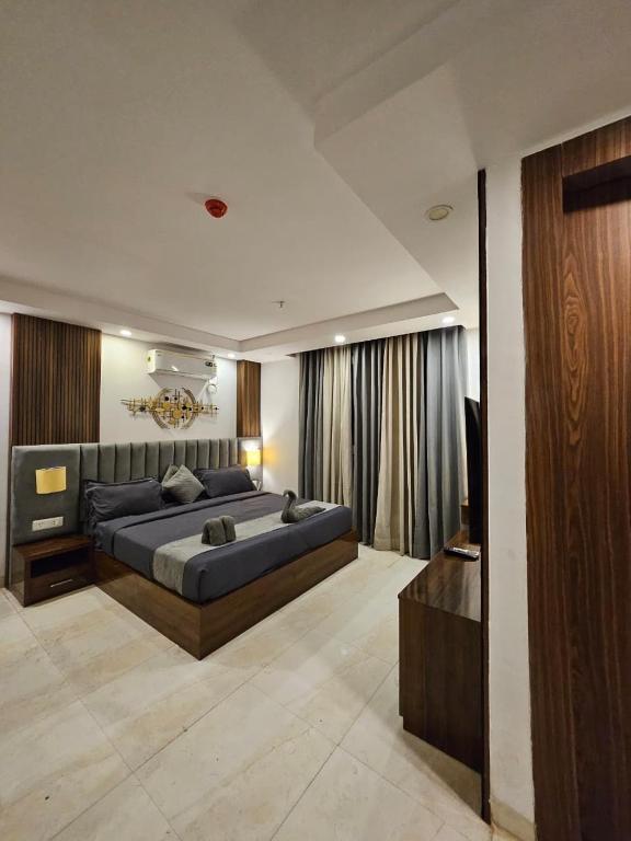 a large bedroom with two beds and a television at Elevenstay in Ghaziabad