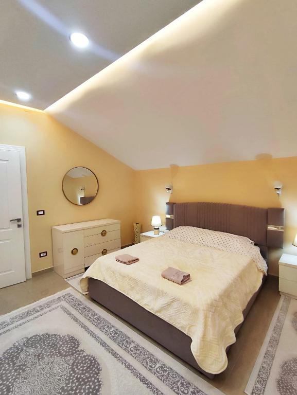 a bedroom with a large bed and a large rug at Zafir Apartment in Korçë