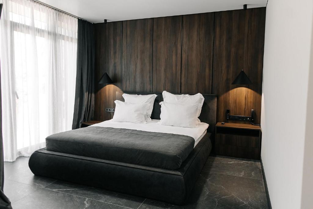 a bedroom with a large bed with wooden walls at Relax Resort in Reshetilovskiy Kut