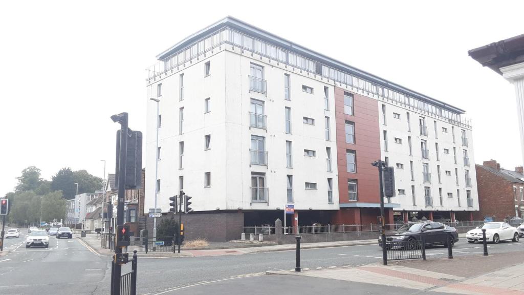 a white building on the corner of a city street at Elegant three bedroom flat in Darlington