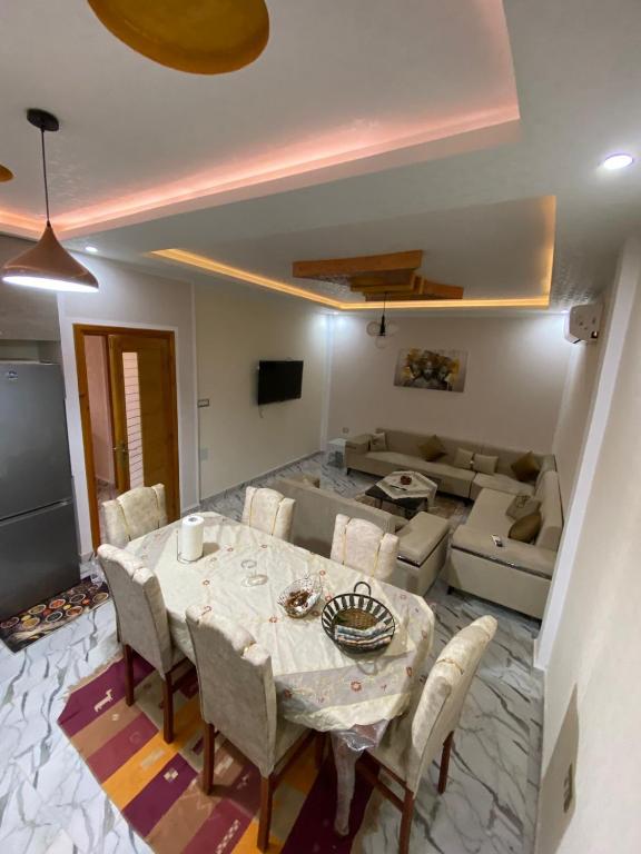 a dining room with a table and a couch at Dar Hamma in Tozeur