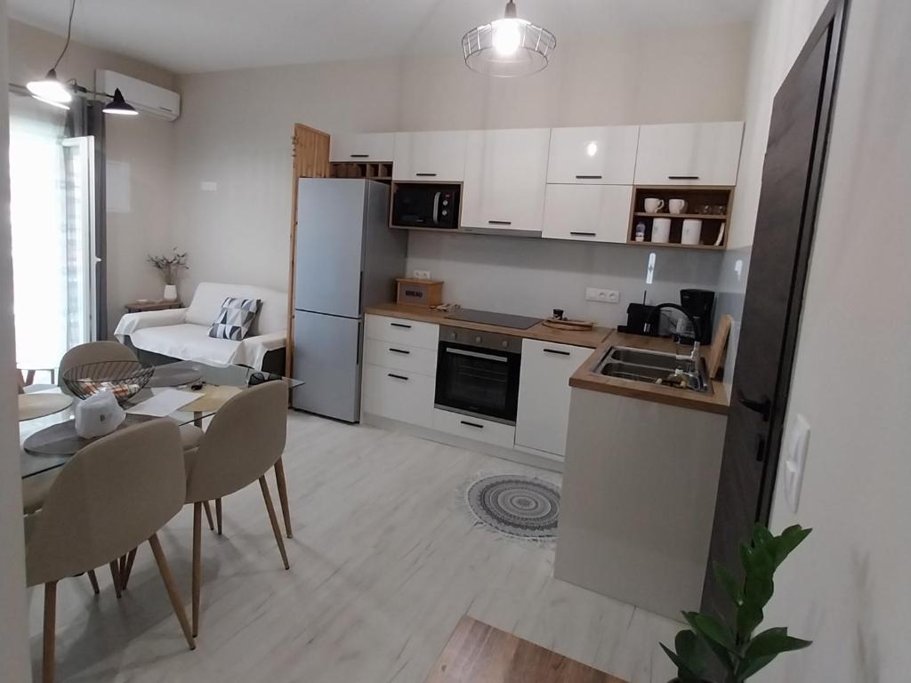a kitchen and living room with a table and a dining room at Boboli Holiday House Acharavi Corfu in Acharavi