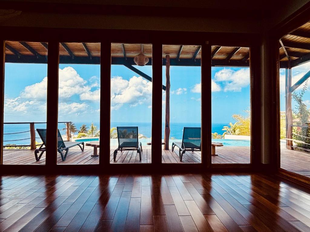 an open room with a view of the ocean at Gone Tropical Luxury Villa in Soufrière