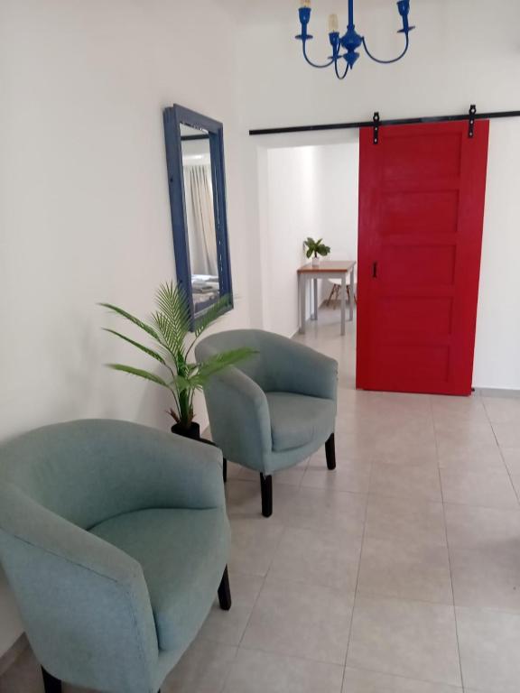 a living room with two chairs and a red door at Casa Esmeralda in Concordia