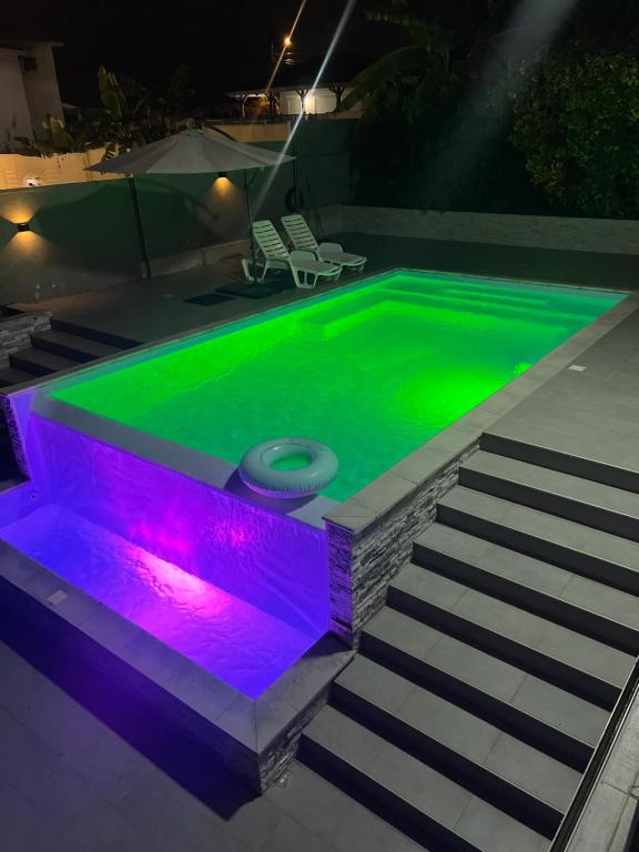 a swimming pool with green and purple lighting at Appartement Acajou Pool & Serenity in Le Lamentin