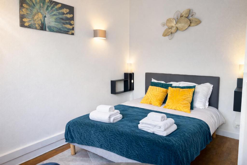 a bedroom with a bed with towels on it at L'Agapanthe - Proche Gare in Saint-Pierre-des-Corps