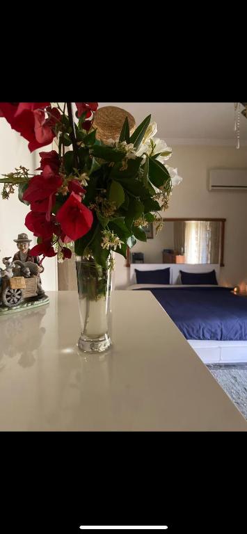 a vase filled with red and white flowers on a table at Master private room in shared appartement in Athens